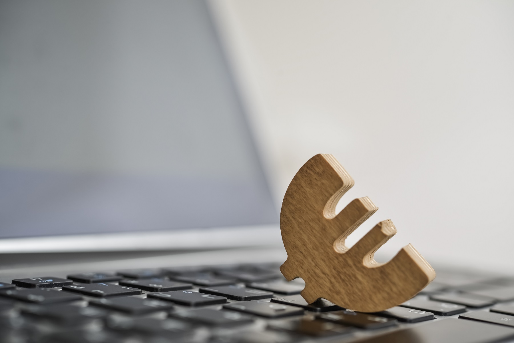 Eurozeichen liegt auf Laptop - Umsatzsteuer für den EU-Onlinehandel